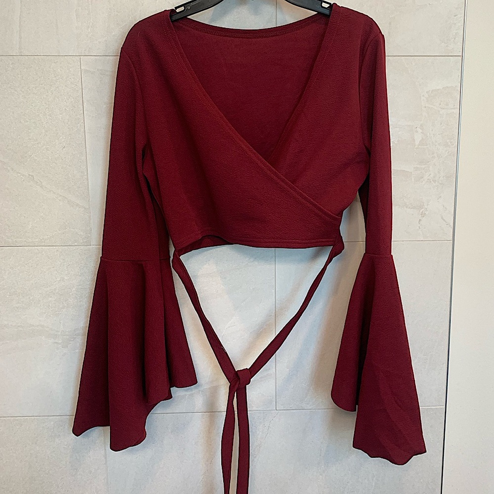 Burgundy crop top with bell shaped long sleeves, with tie wrap around waist
